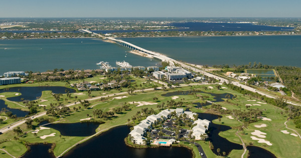 Aerial view of a long bridge over water with nearby homes