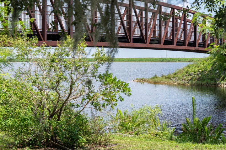 Bridge spanning above a lake surrounded by trees.