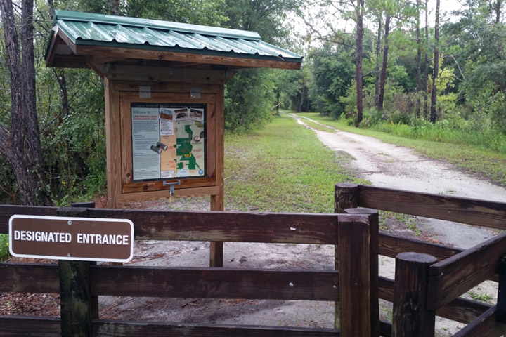Wooden gate marking the entrance to a nature trail.